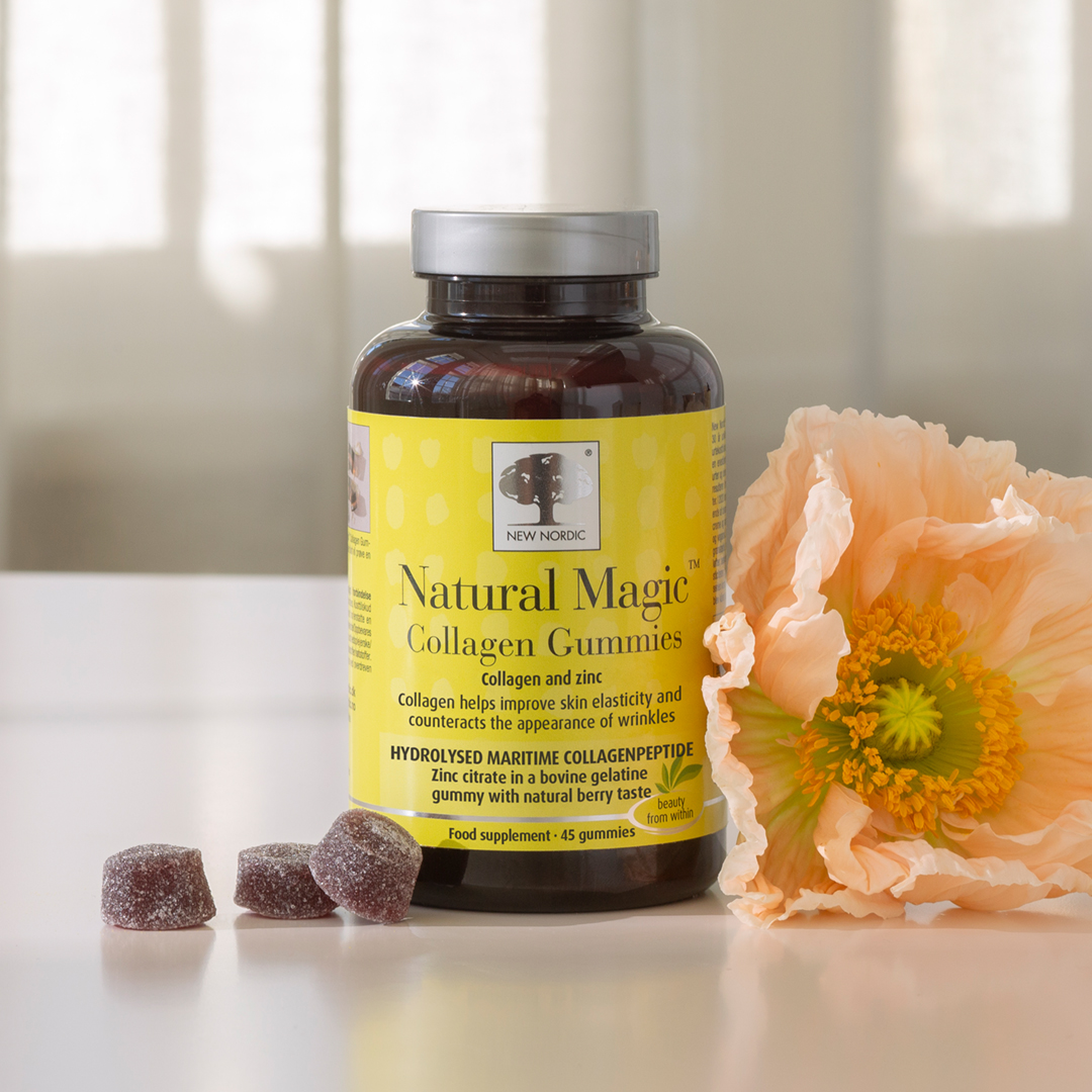 Natural Magic™ Collagen Gummies jar with a flower and some gummies on a table.